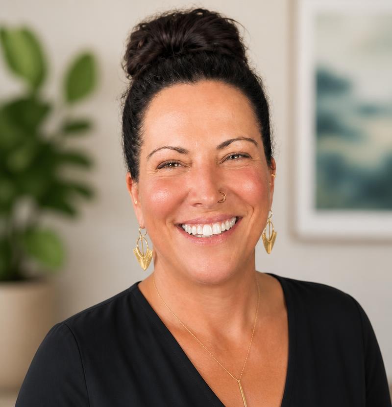 Shannon smiling warmly in a warm-toned room with soft natural light